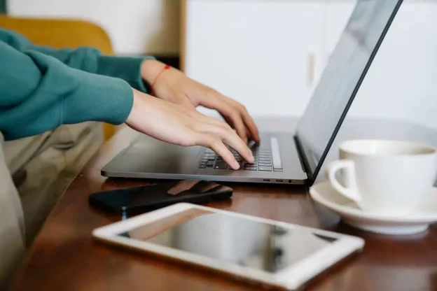 Freelancer typing on laptop while working remotely image