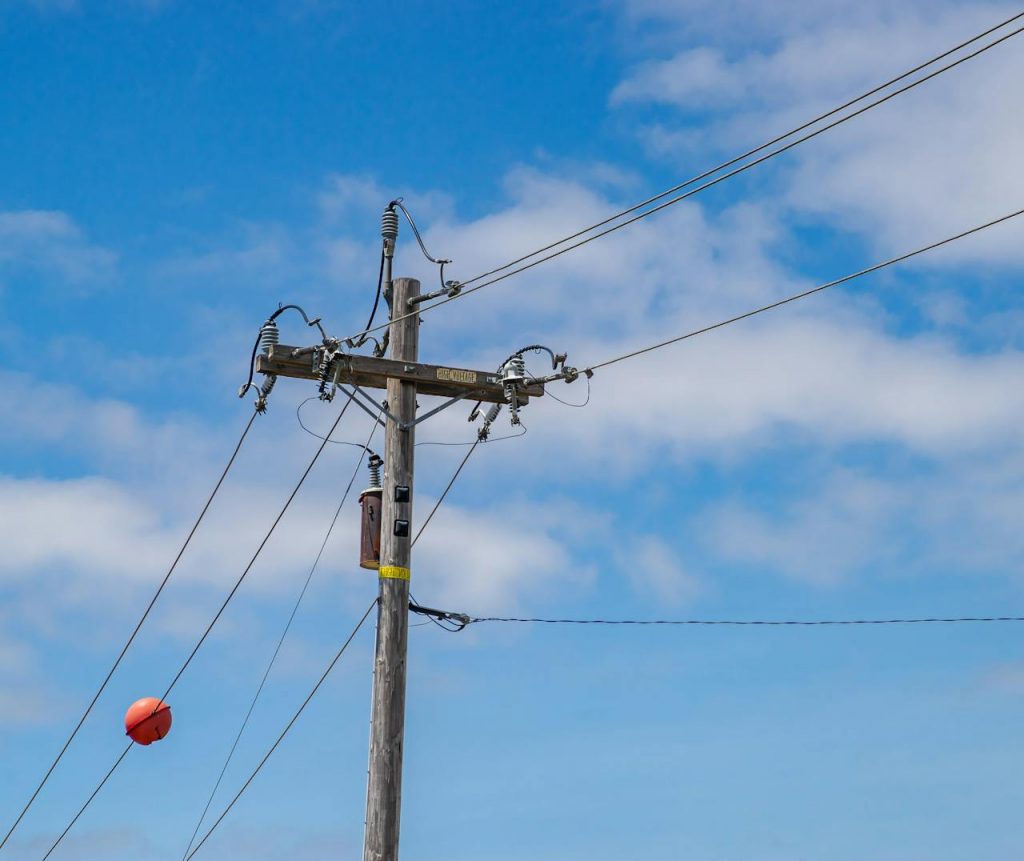 An orange ball on top of a power pole