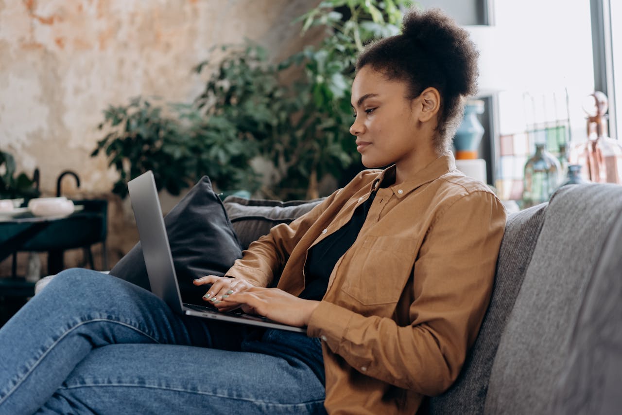 Woman Working on Macbook on Gray Sofa