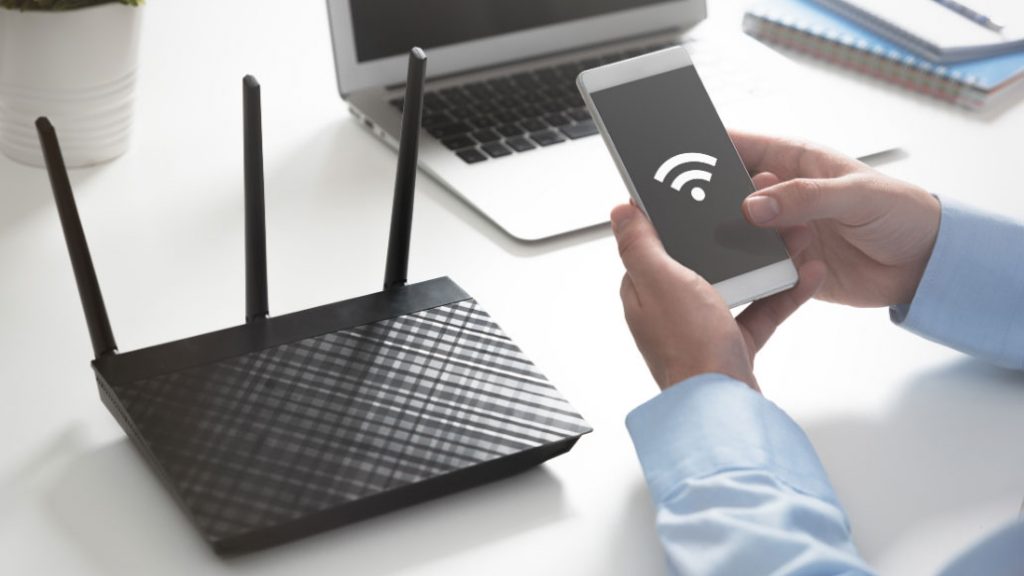 Man holding phone connecting to wifi